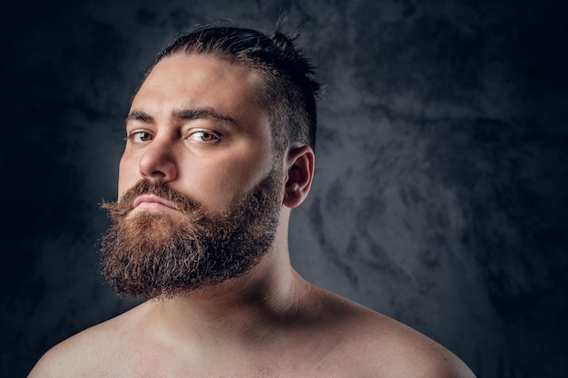 Photo gratuite portrait en gros plan d'un homme à barbe torse nu sur fond gris.