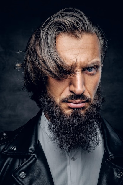 Photo gratuite portrait en gros plan d'un homme barbu aux cheveux longs, en studio, à l'air sauvage.