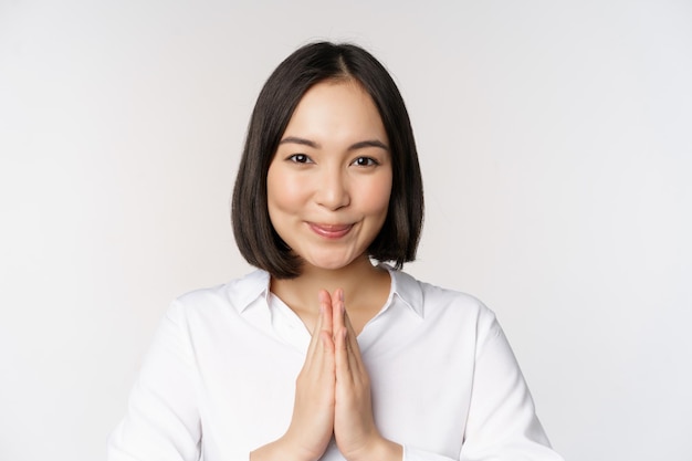 Photo gratuite portrait en gros plan d'une jeune femme japonaise montrant namaste merci geste arigatou debout sur fond blanc