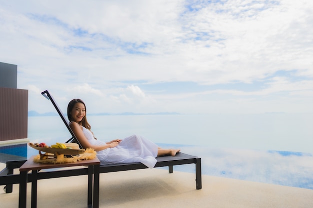 Portrait de jeune femme asiatique se détendre sourire heureux autour de la piscine dans l'hôtel et resort