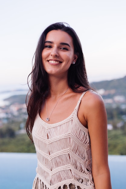 Photo gratuite portrait of happy caucasian calme femme romantique au look décontracté avec des cheveux longs portant des boucles d'oreilles et collier sur fond incroyable belle vue sur les montagnes vertes