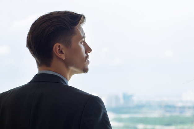 Photo gratuit portrait de profil serious man looking out window