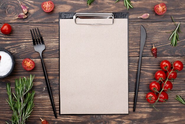 Presse-papiers avec tomates et couverts sur table