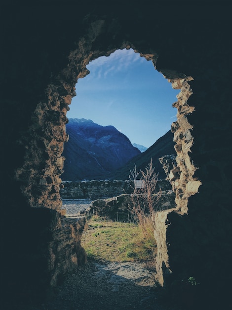 Photo gratuite prise de vue verticale de l'intérieur d'une grotte avec une montagne