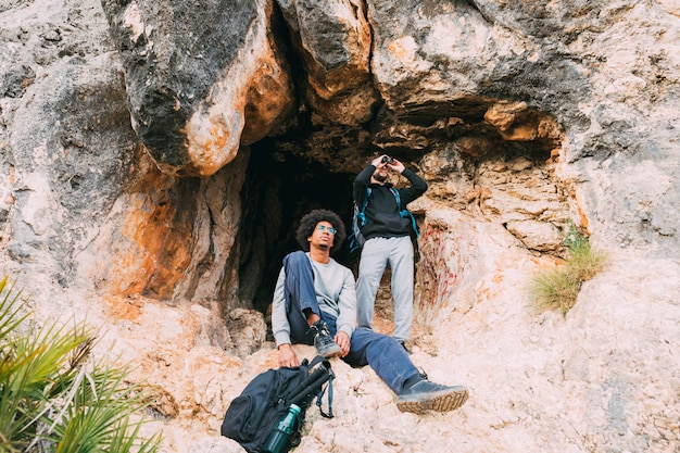 Photo gratuite randonneurs devant la grotte