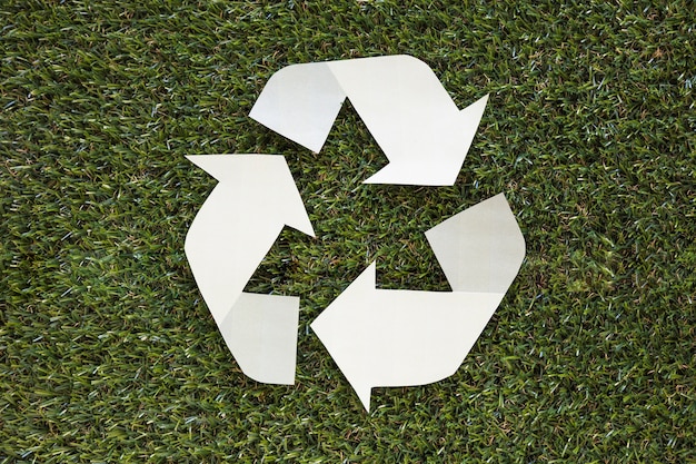 Photo gratuite recycler le symbole sur l'herbe