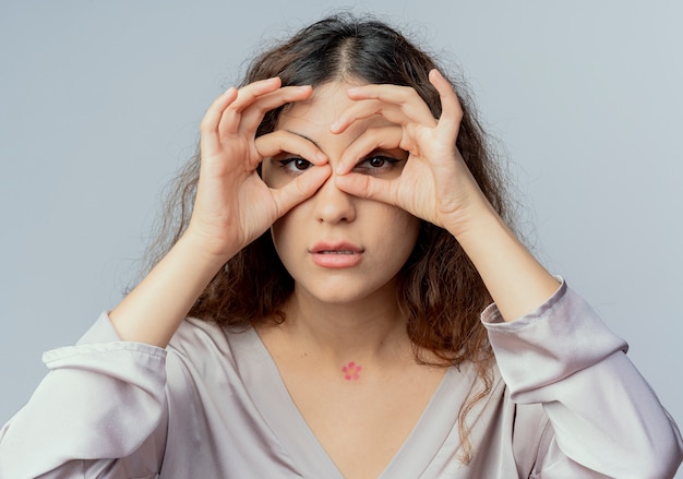 Photo gratuit regardant la caméra jeune employé de bureau jolie femme montrant le geste de regard isolé sur fond blanc