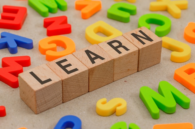 Photo gratuite retour au concept de l'école avec des lettres de l'alphabet, des cubes en bois sur papier vue grand angle.