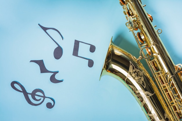 Photo gratuite saxophones doré avec des notes de musique sur fond bleu