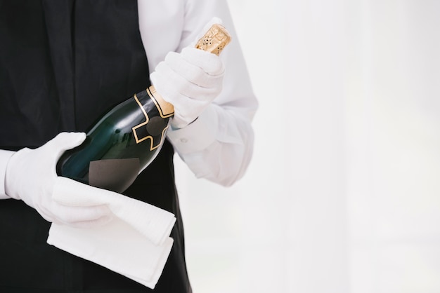 Photo gratuite serveur en uniforme présentant le champagne