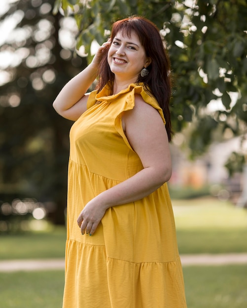 Photo gratuite smiley femme posant dans une robe jaune