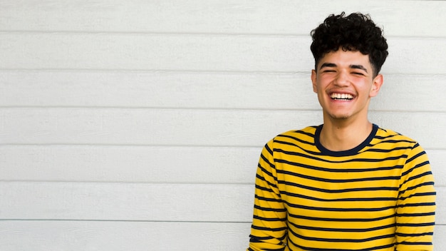 Photo gratuite souriant jeune homme ethnique aux cheveux bouclés