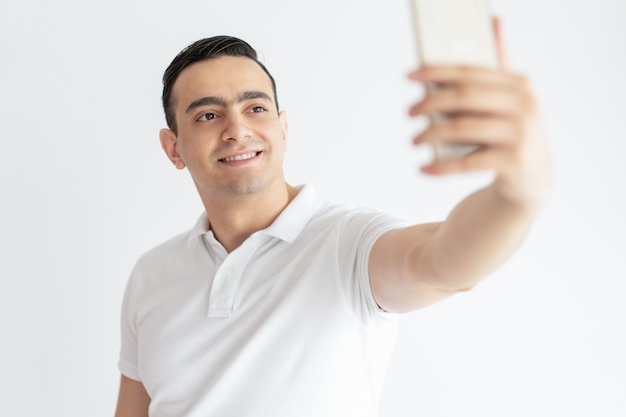 Photo gratuite souriant jeune homme prenant selfie photo sur smartphone