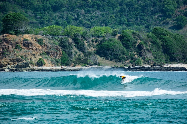 Photo gratuite surfer sur une vague bleue.