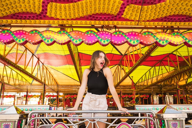 Photo gratuit surpris jeune femme debout sous la tente décorée au parc d&#39;attractions