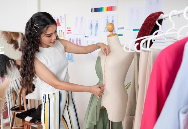 Photo gratuit tailleur asiatique femme travaillant sur des vêtements dans un atelier de couture