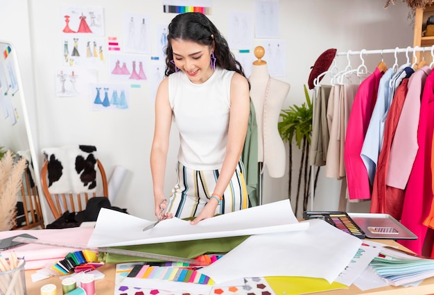 Photo gratuit tailleur asiatique femme travaillant sur des vêtements dans un atelier de couture