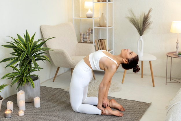 Photo gratuit tir complet femme faisant du yoga à l'intérieur