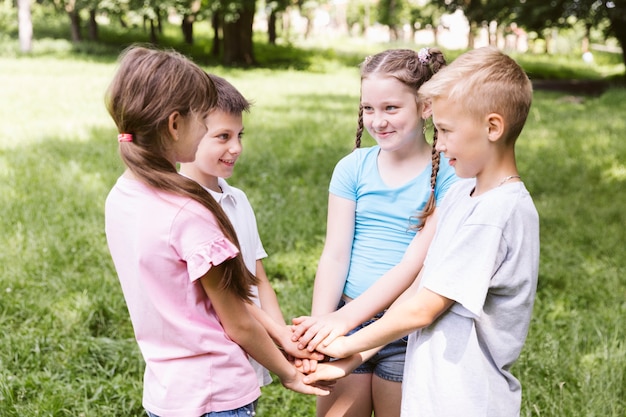 Photo gratuite tir moyen, enfants, tenant mains, ensemble