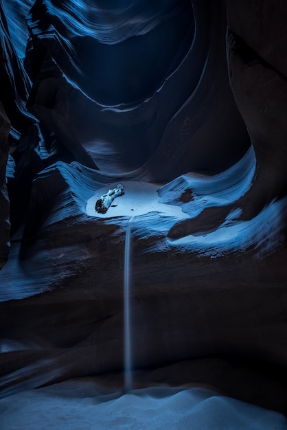 Photo gratuite tir vertical d'une belle grotte avec du sable qui coule dans l'obscurité à antelope canyon, usa