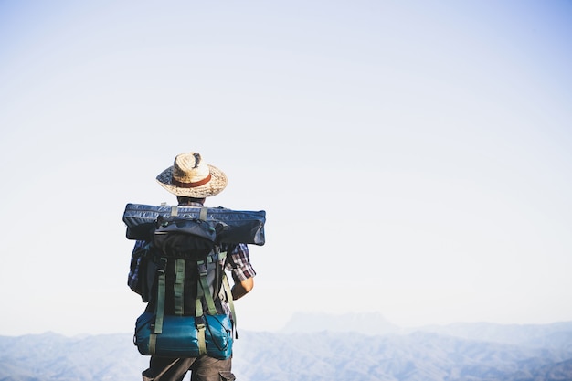 Photo gratuit touriste du sommet de la montagne. rayons de soleil. homme porter grand sac à dos contre la lumière du soleil