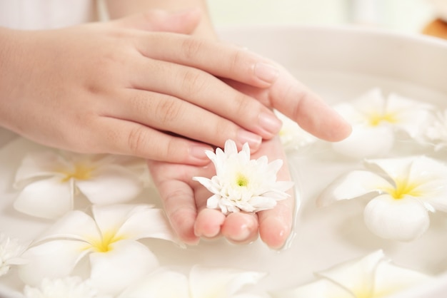 Photo gratuit traitement et produit de spa. fleurs blanches dans un bol en céramique avec de l'eau pour l'aromathérapie au spa.