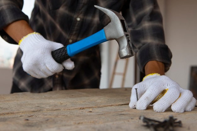 Travailleur de la construction à l'aide d'un marteau sur le chantier