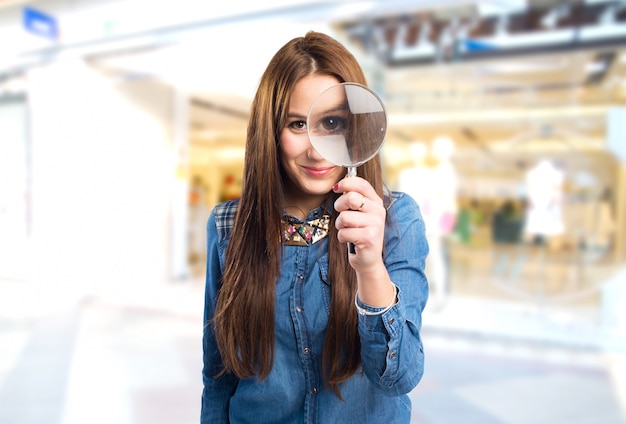 Photo gratuite trendy jeune femme avec une loupe en face de l'œil