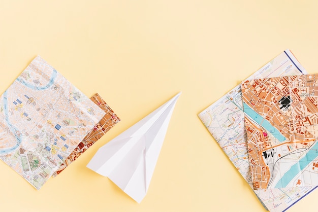 Photo gratuit variété de cartes avec avion en papier blanc sur fond beige