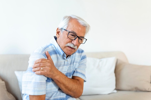 Photo gratuite un vieil homme âgé souffrant de douleurs à l'épaule un homme âgé bouleversé ressent une douleur soudaine au dos des muscles une blessure de tension à la maison un grand-père touchant l'épaule souffrant d'arthrose arthrite