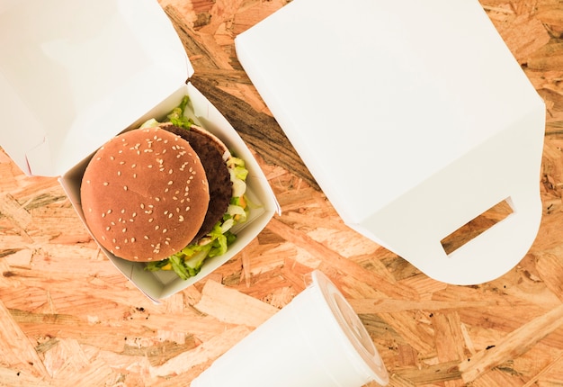 Photo gratuite vue aérienne du burger dans un paquet sur le fond en bois