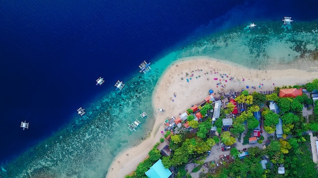 Photo gratuit vue aérienne de la plage de sable avec des touristes en train de nager dans une belle eau de mer claire de l&#39;île de sumilon atterissant près d&#39;oslob, cebu, aux philippines. - accélérer le traitement des couleurs.