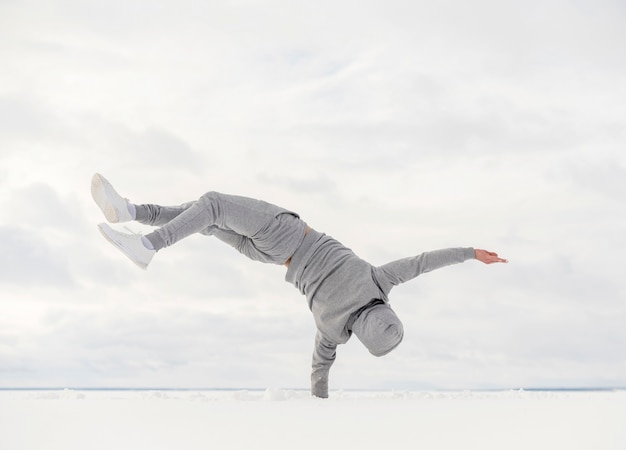 Photo gratuite vue arrière du danseur masculin équilibrant son corps d'une part