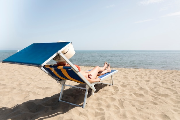 Photo gratuite vue arrière, femme, sur, chaise plage, bronzer