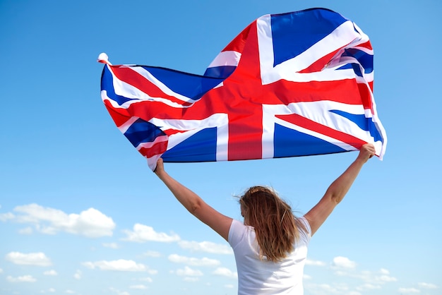 Photo gratuite vue arrière de la jeune femme agitant le drapeau britannique