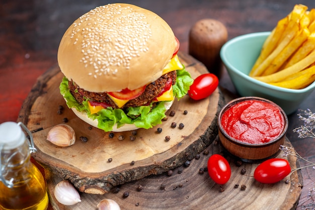 Photo gratuite vue avant de délicieux hamburger de viande avec des frites sur fond sombre