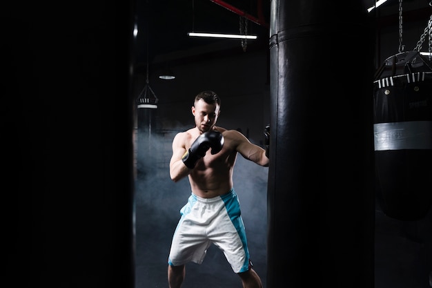 Photo gratuite vue avant de la formation de boxeur masculin pour une compétition