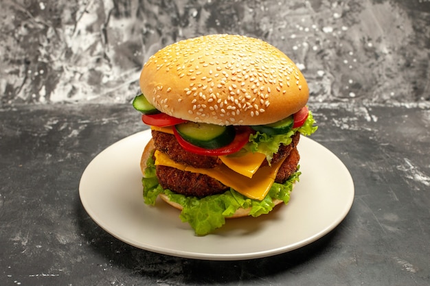 Photo gratuite vue avant de la viande savoureuse hamburger avec des légumes sur le pain de restauration rapide sandwich de surface sombre