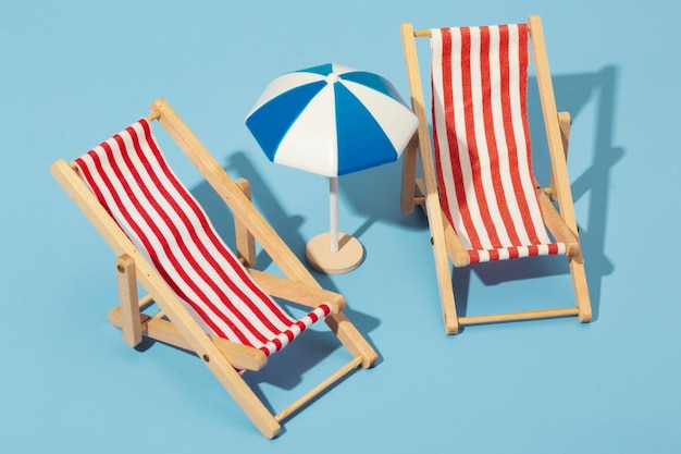 Photo gratuite vue des chaises de plage d'été avec parasol