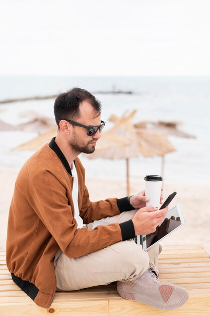 Vue côté, de, homme, travailler plage, quoique, avoir café