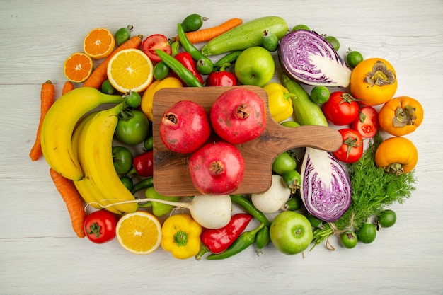 Photo gratuite vue de dessus différents légumes avec des fruits sur fond blanc nourriture régime santé couleur mûre salade