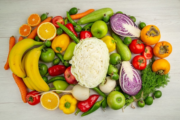 Photo gratuite vue de dessus différents légumes avec des fruits frais sur fond blanc clair salade nourriture santé couleur régime mûr