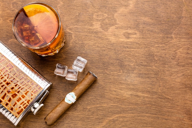 Photo gratuit vue de dessus du whisky avec orange et cigare avec espace copie