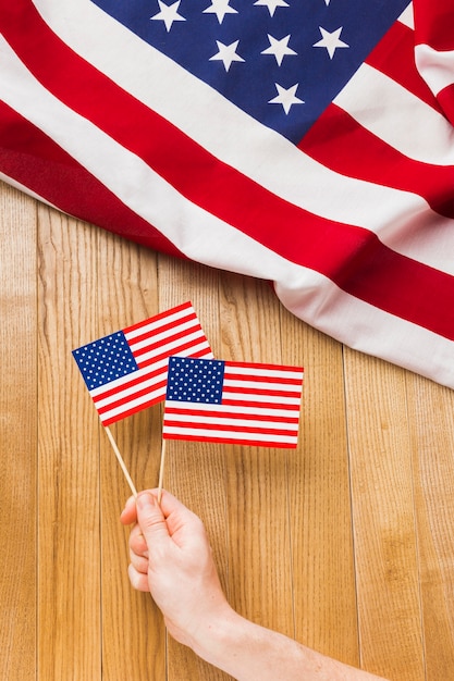 Photo gratuite vue de dessus de la main tenant des drapeaux américains