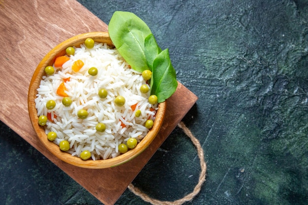 Photo gratuite vue de dessus savoureux riz bouilli avec des haricots verts à l'intérieur de la plaque sur un bureau sombre