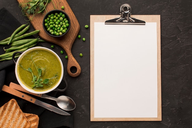 Photo gratuite vue de dessus de la soupe aux pois d'hiver dans un bol avec bloc-notes