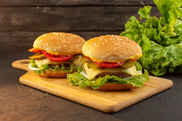 Photo gratuite une vue de face burger de poulet avec fromage et salade verte sur le bureau en bois et sandwich restauration rapide