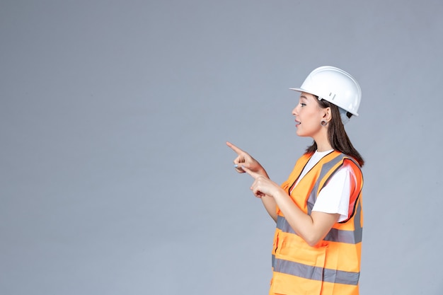 Photo gratuite vue de face du constructeur féminin en uniforme sur mur blanc