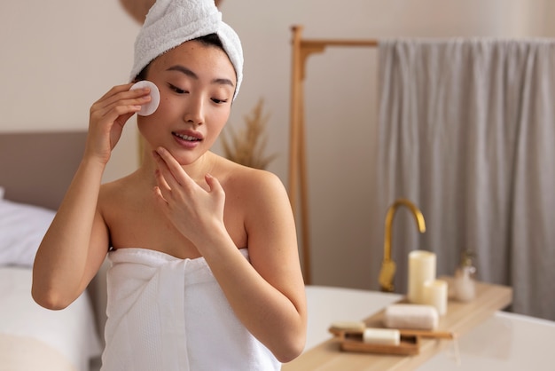 Photo gratuite vue de face femme à l'aide d'un coton