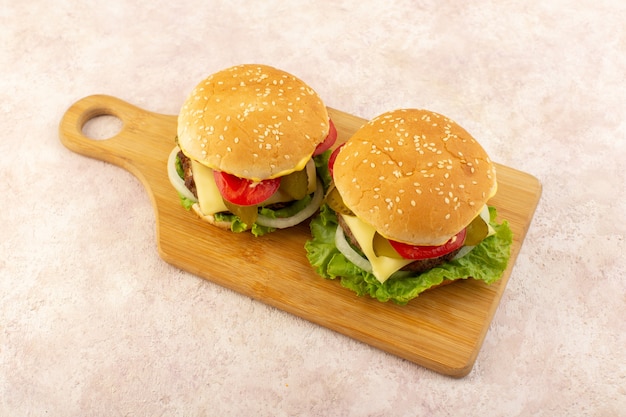 Photo gratuite une vue de face des hamburgers de viande avec légumes et salade verte sur la table en bois